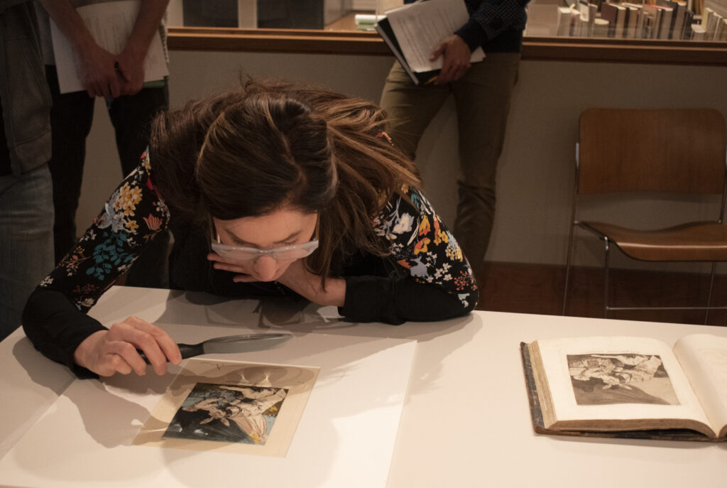 woman examining piece of art