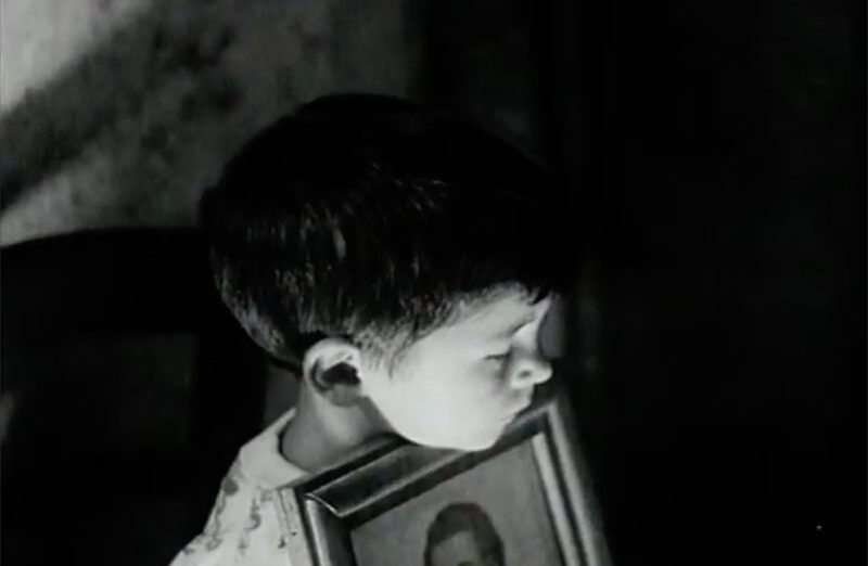 A child holds a framed portrait