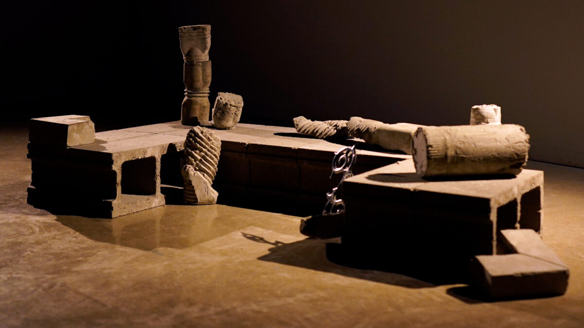 Cinder blocks, construction debris, decorative elements in a dark room with directional light