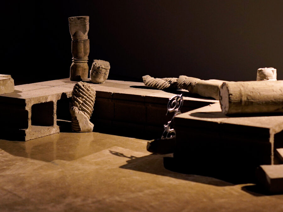 Cinder blocks, construction debris, decorative elements in a dark room with directional light