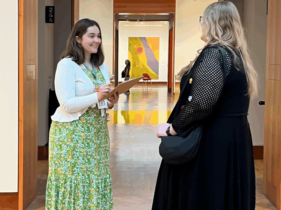 Two women with long hair are seen in a gallery of the Chazen Museum of Art.