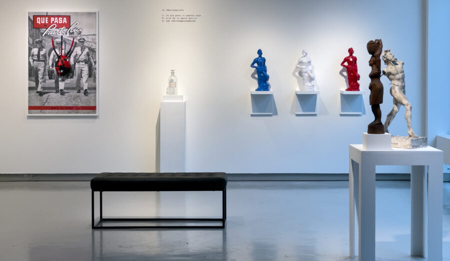 White gallery interior with various objects on wall and tables